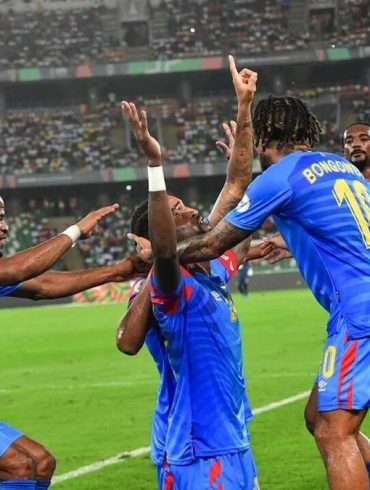 Trophée de la Coupe du monde avec le drapeau de la RD Congo pour illustrer le barrage intercontinental vers le Mondial 2026.