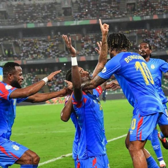Trophée de la Coupe du monde avec le drapeau de la RD Congo pour illustrer le barrage intercontinental vers le Mondial 2026.