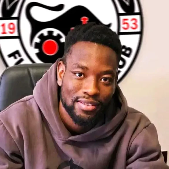 Josué Tiendrébéogo pose avec son contrat lors de sa signature à l’IMT Belgrade.