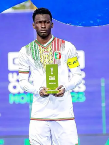 Issa Tounkara pose avec la tunique malienne, alors que son départ vers l’Angleterre est évoqué.