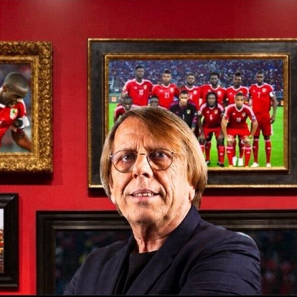 Claude Le Roy devant des photos de la sélection du Congo