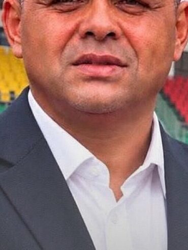 Portrait d’Éric Alain Mantot devant des tribunes de stade