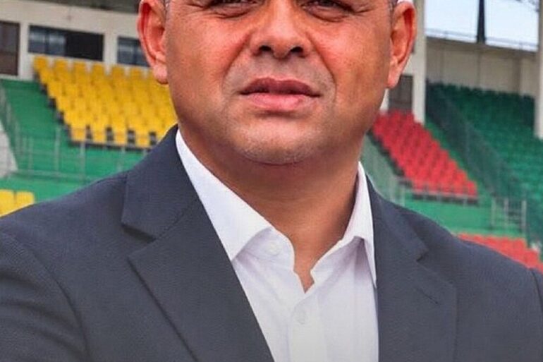 Portrait d’Éric Alain Mantot devant des tribunes de stade