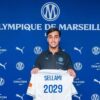 Yanis Sellami présentant un maillot de l’OM marqué 2029